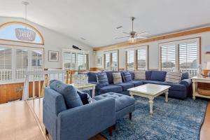 a living room with blue couches and a table at 1030 - La Ballena Cottage in Corolla