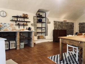 a kitchen with a table and a clock on the wall at Loft nel borgo di Tavernelle in Tavernelle