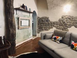 a living room with a couch and a stone wall at Loft nel borgo di Tavernelle in Tavernelle
