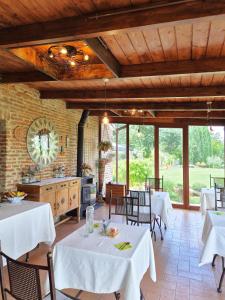 a kitchen and dining room with white tables and chairs at Il casale di Sandra in Chiusi