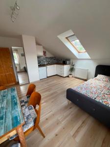 a bedroom with a bed and a table and a kitchen at Apartmán U nás na vsi in Nový Jáchymov