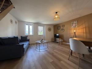 a living room with a couch and a table at Mon petit cocon Seurrois in Seurre