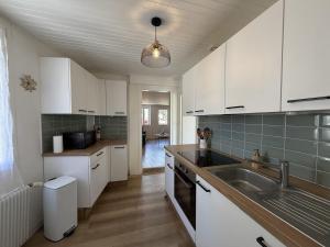 a kitchen with white cabinets and a sink at Mon petit cocon Seurrois in Seurre