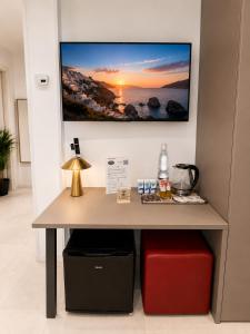 a table with a tv on a wall at Sicily Luxury Rooms in Palermo