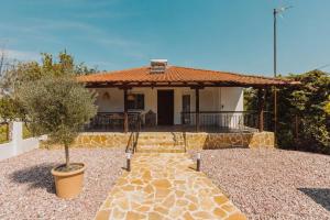 a small house with a patio with a tree at Nikolaidis Villa Family Friendly in Nea Kallikrateia