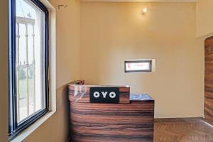 a sign that says oxy sits on a table next to a window at Hotel O New Friends Hotel in Prayagraj