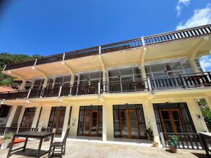 a large yellow building with a table in front of it at Views Backpackers Hostel in Nongkhiaw