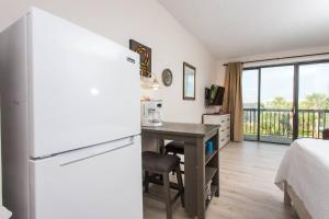a kitchen with a desk and a refrigerator and a bed at Pirates Bay Condominiums Unit 302A in Fort Walton Beach
