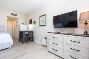 a bedroom with a dresser with a flat screen tv at Pirates Bay Condominiums Unit 302A in Fort Walton Beach +28 photos