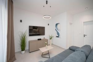a living room with a blue couch and a table at Holiday home Mirage in Sukošan