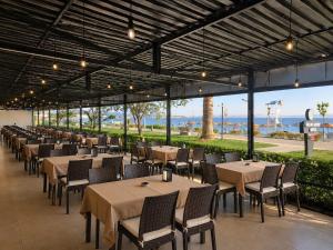 a row of tables and chairs with the ocean in the background at Grand Erdek Hotel in Erdek