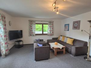 a living room with a couch and a tv at Ferienwohnung Schautzgy in Reutte
