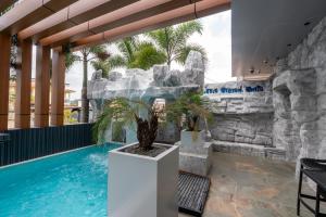 a pool in a hotel with a rock wall at Hotel Elegance NV in Paramaribo
