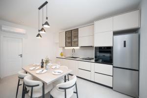 a kitchen with a table and chairs and a refrigerator at Holiday home Mirage in Sukošan