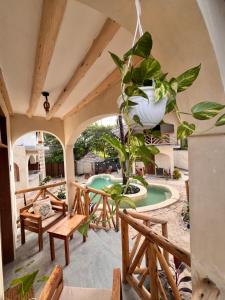 a patio with a potted plant and a pool at Jambiani Kite Lodge in Jambiani