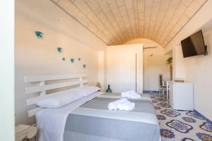 a bedroom with a large bed with towels on it at Tenuta Monsalvato in Otranto