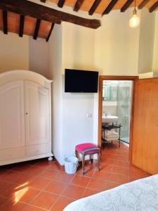 a bedroom with a bed and a tv on the wall at Il casale di Sandra in Chiusi