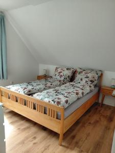 a bed with a wooden frame in a room at Ferienwohnung Knoll in Lähden