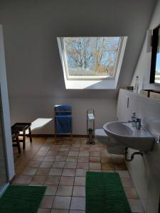 a bathroom with a sink and a skylight at Ferienwohnung Knoll in Lähden