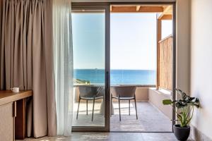 a room with a balcony with a view of the ocean at Kakkos Terra Blu Hotel in Ierapetra