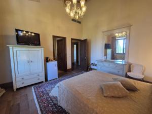 a bedroom with a bed and a dresser and a television at Agriturismo Camporotondo in Scarlino