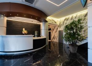 a lobby with a counter and a plant at Hotel Elegance NV in Paramaribo +17 photos