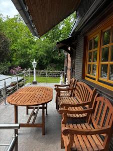 three wooden benches and a table on a patio at Meisehof in Buchholz Aller
