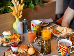 a table topped with plates of breakfast foods and drinks at Pullman Lyon in Lyon