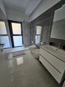a bathroom with two toilets and a sink and a tub at Sabotino suite in Avezzano +5 photos