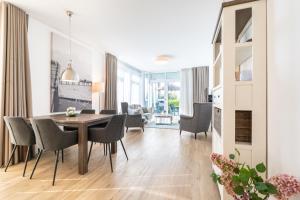 a dining room and living room with a table and chairs at Südkap C-02 in Pelzerhaken