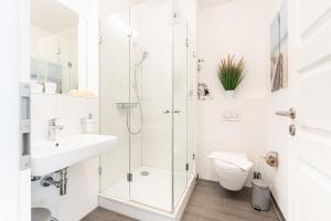 a bathroom with a shower and a toilet and a sink at Südkap C-02 in Pelzerhaken +55 photos