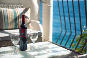 a bottle of wine and two glasses on a table at Robinson Ilijana in Gdinj +19 photos
