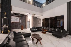 a living room with black leather couches and a table at Hotel Elegance NV in Paramaribo