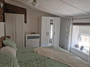 a bedroom with a bed with a green comforter at casa leia in Porto Nobre