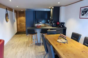 a kitchen with a wooden table and blue cabinets at Gentiane 7 pers - proche pistes in Châtel +22 photos