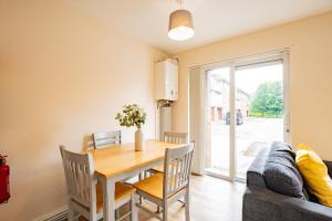 a dining room with a table and a couch at Central Limerick Bright & Spacious Apartment in Limerick +9 photos
