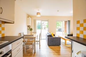 a kitchen and living room with a table and chairs at Central Limerick Bright & Spacious Apartment in Limerick
