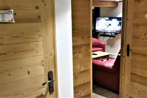 a door leading into a room with a tv at Gentiane 7 pers - proche pistes in Châtel