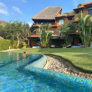 a swimming pool in front of a house at 1 bdrm condo, Manzanillo Bay, Troncones in Troncones