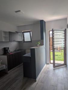 a kitchen with a counter in the middle of a room at Cozy House Corbu in Corbu