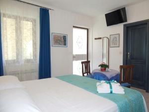 a bedroom with a bed and a table and a window at Apartments Ruby in Funtana
