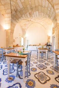 a dining room with tables and chairs on a rug at Tenuta Monsalvato in Otranto
