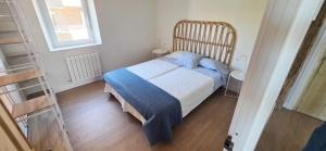 a bedroom with a bed with a blue blanket at Sand House Gorliz By Kima Gestión in Górliz-Elexalde +15 photos