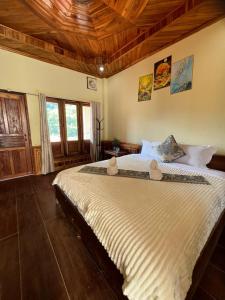 a bedroom with a large bed with a wooden ceiling at Views Backpackers Hostel in Nongkhiaw +93 photos