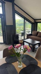 a vase with flowers on a table in a living room at Mountain soul hub будиночок на схилі in Krasnik