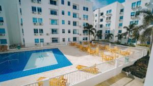 a hotel with a swimming pool and chairs and a building at Familiar 5 piso in Coveñas