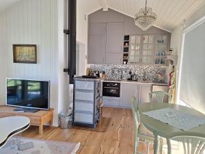 a kitchen with a table and a television and a dining room at Guesthouse in Gustavsberg