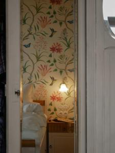 a bedroom with a wallpaper with flowers and birds at Die Gute Stube in Dobritz