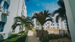 a row of palm trees in front of a building at Familiar 5 piso in Coveñas