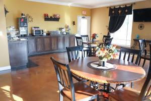 a dining room with a table with flowers on it at Black Gold Inn in Yoakum